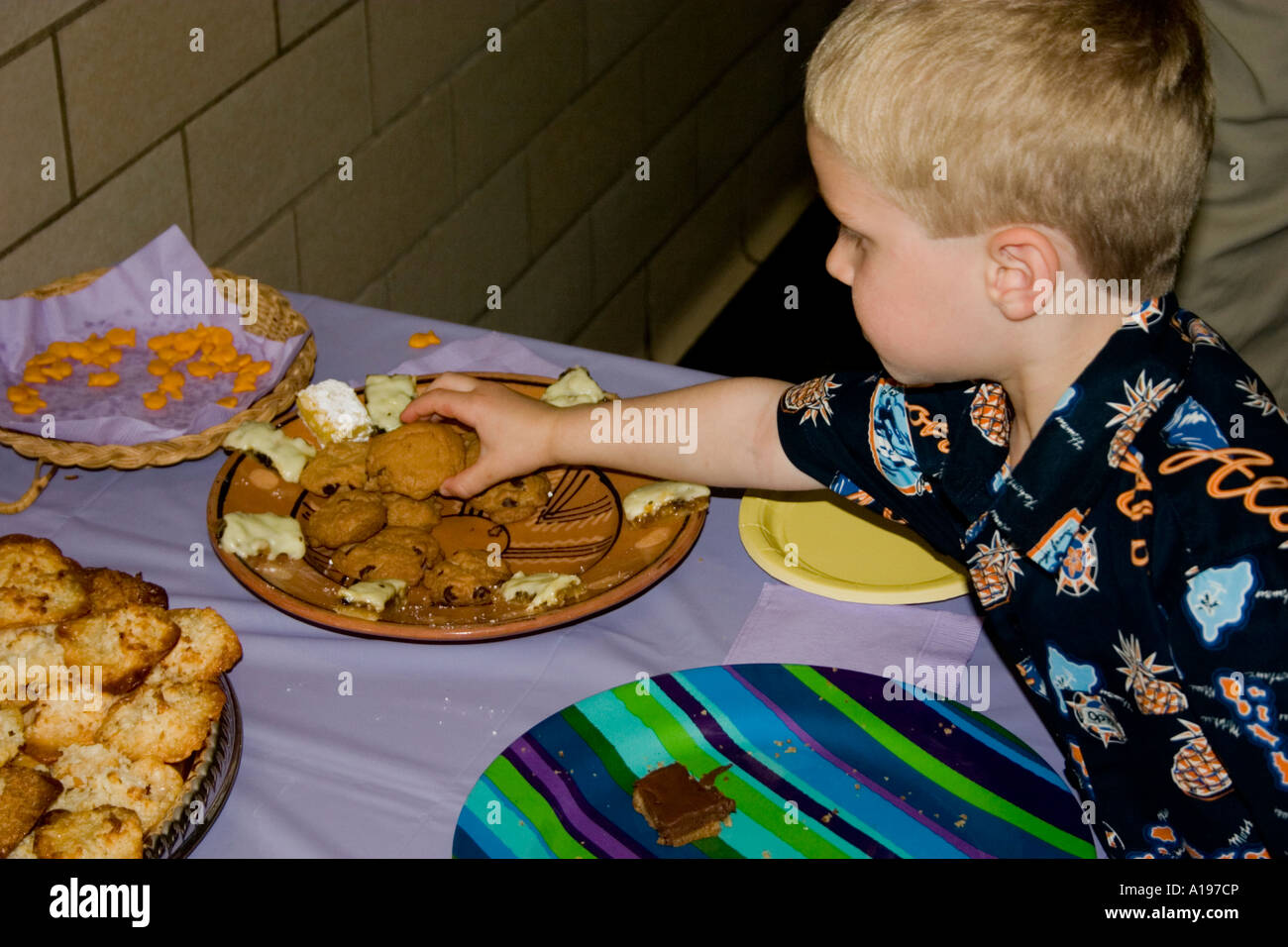 Student age 5 reaching for snack at Crocus Hill School Art Show. St Paul Minnesota USA Stock Photo