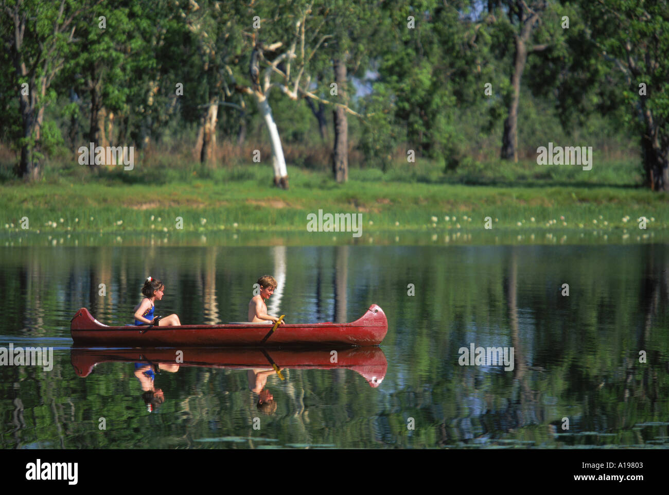 Children canoeing in Annaburroo Billabong at Mary River Crossing near the Arnhem Highway at the Top End Northern Territory Stock Photo