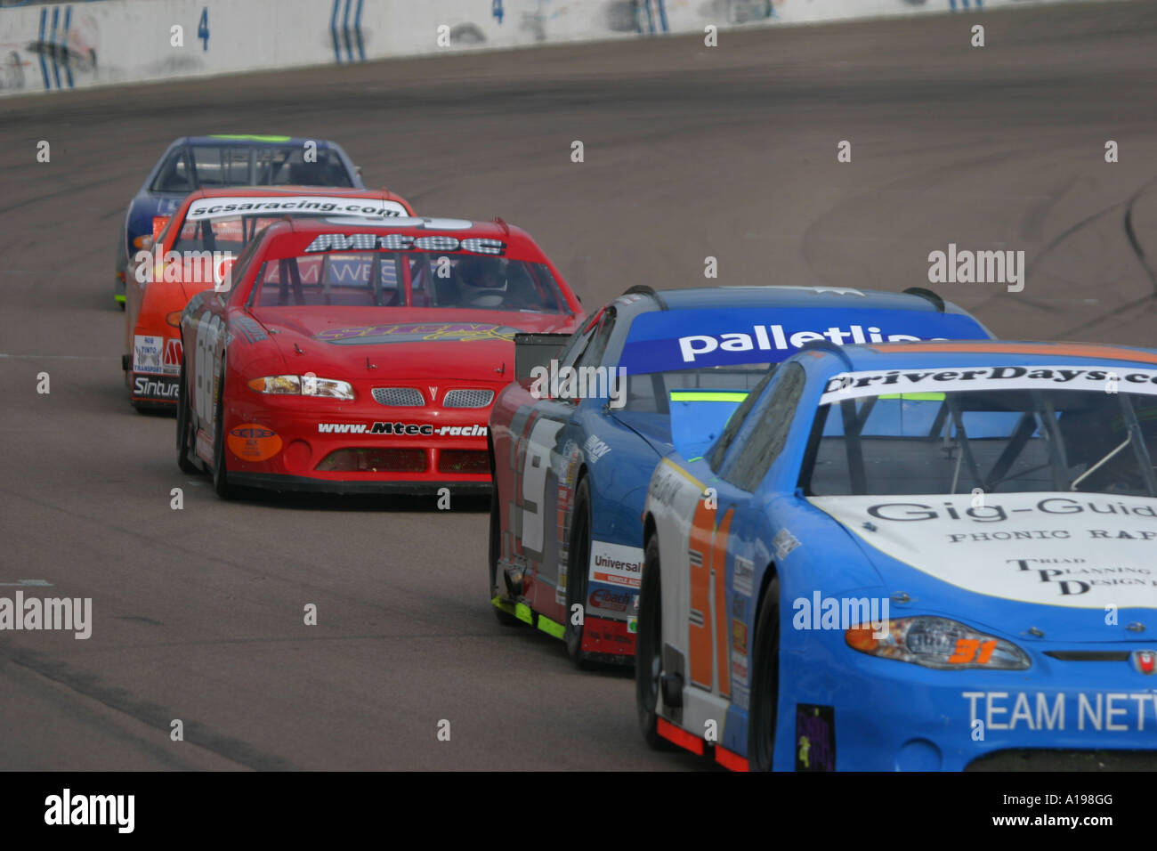 V8 Nascar type stock cars racing on a banked oval circuit Stock Photo ...