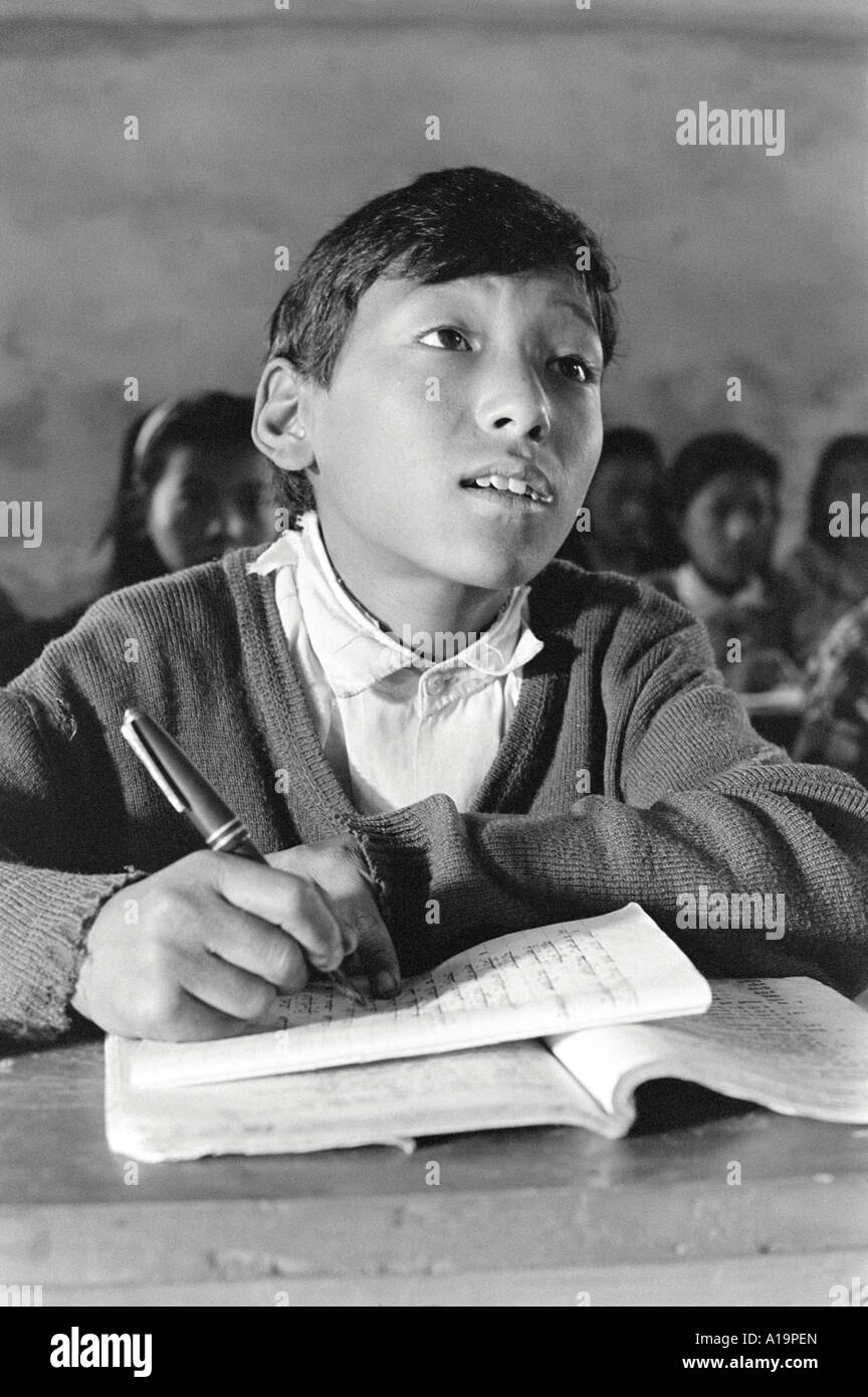B/W of a Sherpa boy writing at his desk in the classroom of a remote Himalayan school in Solukhumbu, Nepal Stock Photo