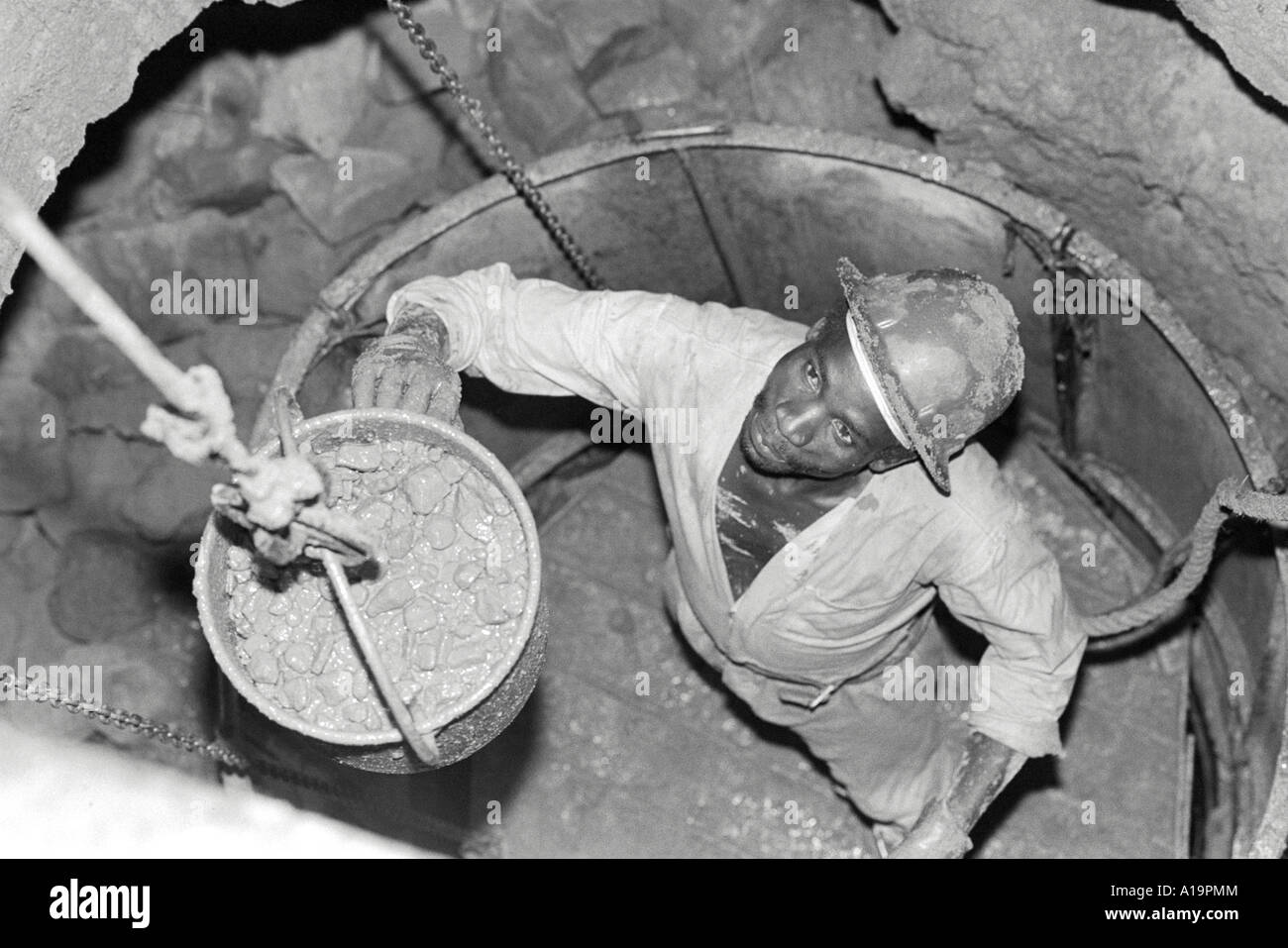 B/W of a water engineer deepening a community water well during a long period of drought. Zimbabwe Stock Photo