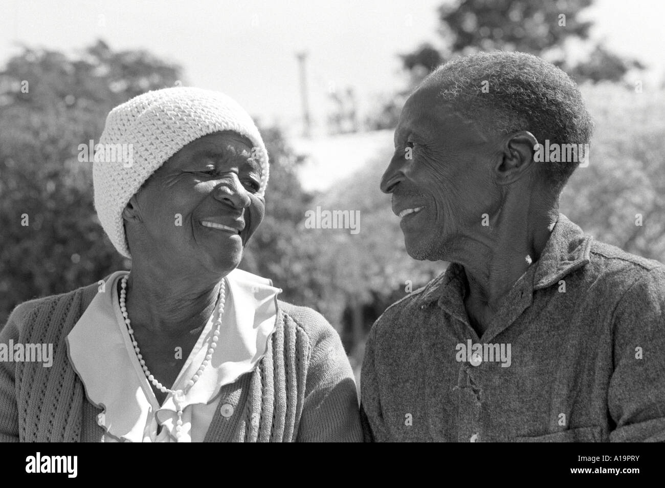 B/W portrait of a happy elderly couple, residents in a care home, looking and smiling at each other.  Harare, Zimbabwe Stock Photo