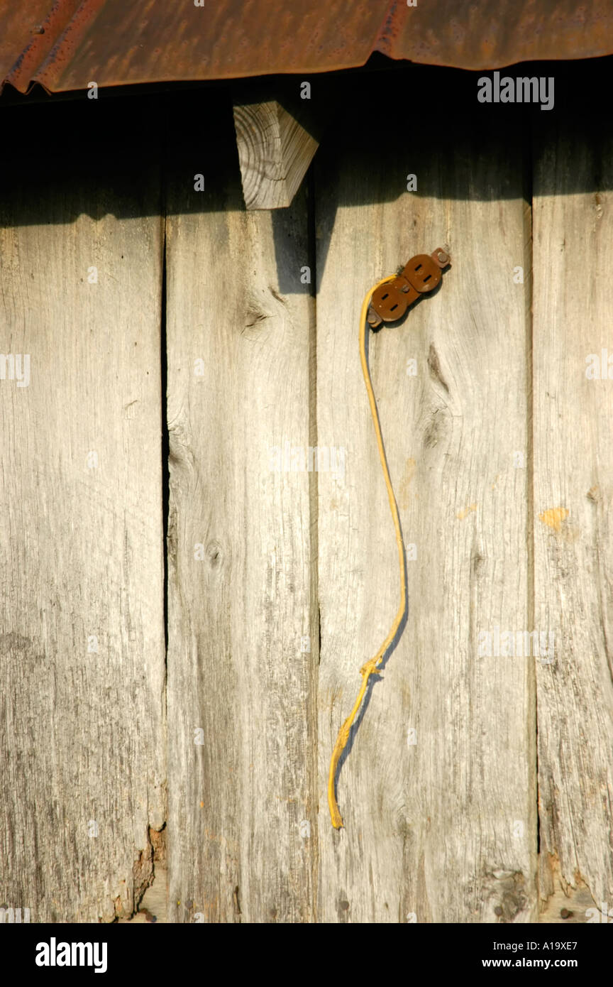 Weathered wooden barn planks with old electrical outlet and wiring
