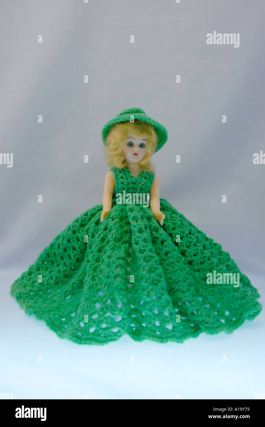 Standing girl doll with blond hair and a green crochet dress and hat Stock Photo