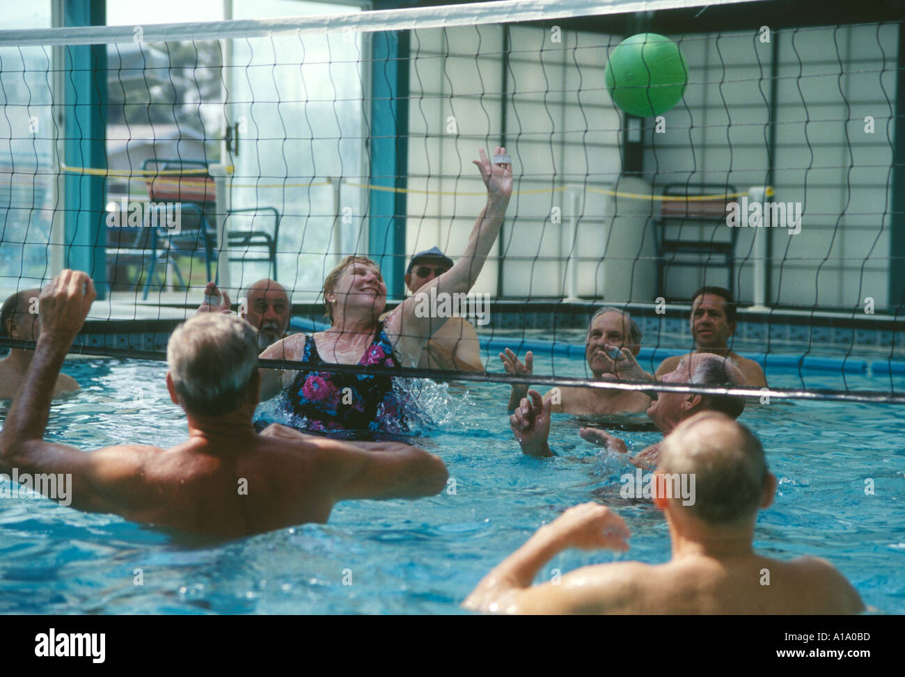 Seniors play pool volleyball in indoor facility Stock Photo Alamy