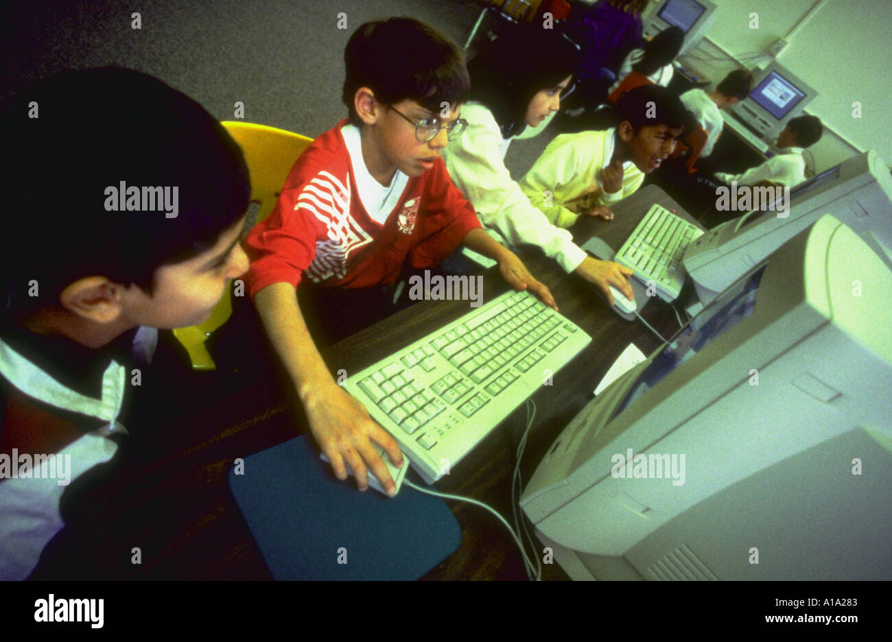 Several fourth grade school children using computers in the computer ...