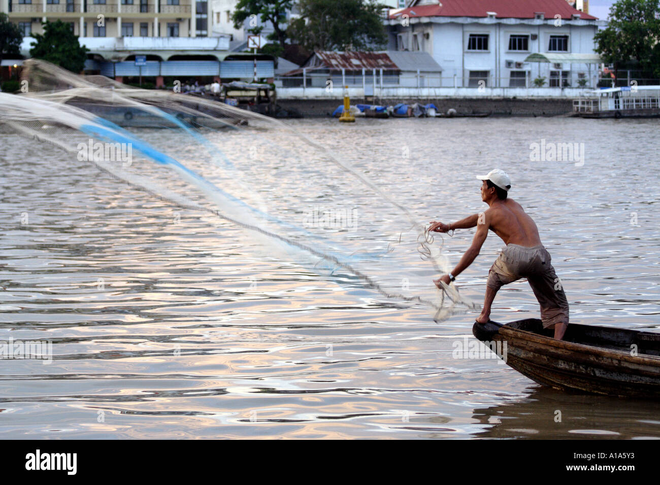 Fisherman casts his net from a boat in the Mekong Delta, Vietnam Stock ...