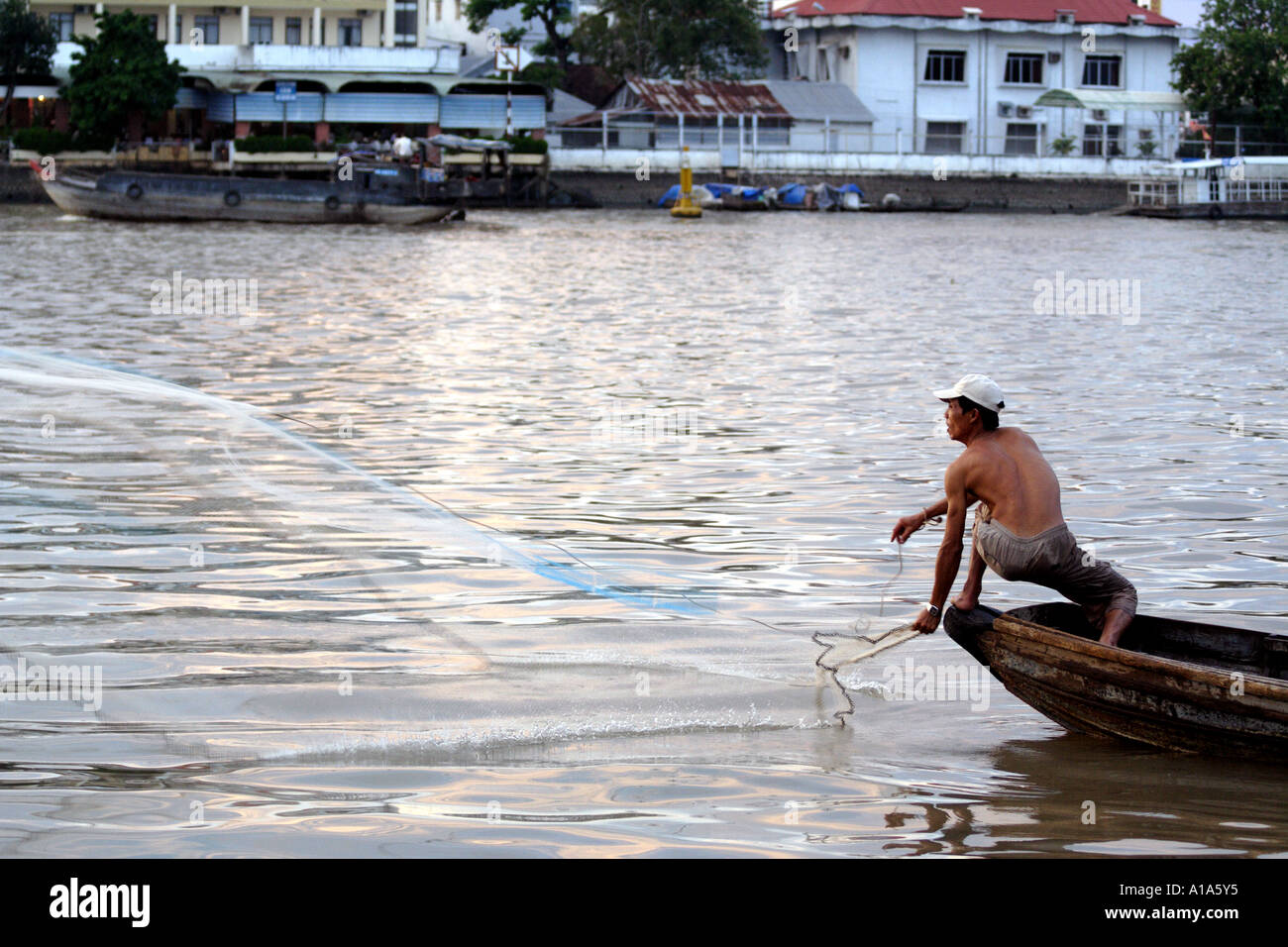 Fisherman casts his net from a boat in the Mekong Delta, Vietnam Stock ...