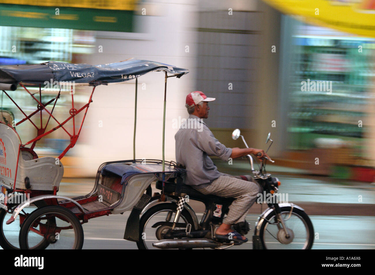 Man pulling a cart for transporting people with  his motorbike in Vihn Long, Mekong Delta,  Vietnam Stock Photo