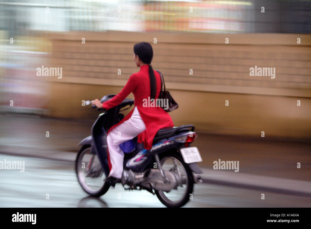 Woman with long black hair on a motorbike Saigon, HCMC, Vietnam Stock Photo