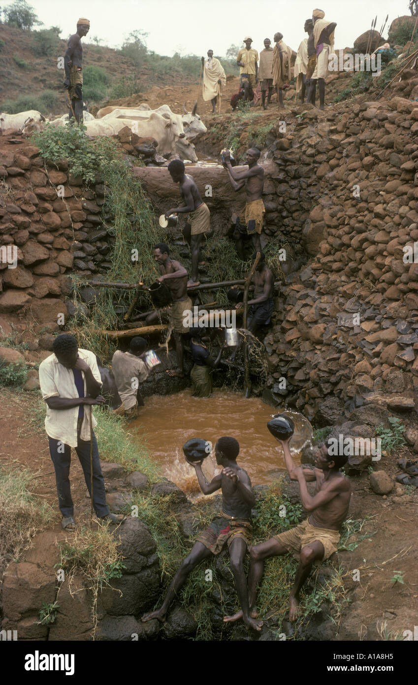 Boran people raising water in giraffe hide buckets at the Singing Wells Marsabit northern Kenya East Africa Stock Photo