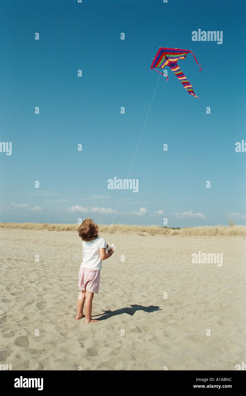 Child flying kite on the beach Stock Photo