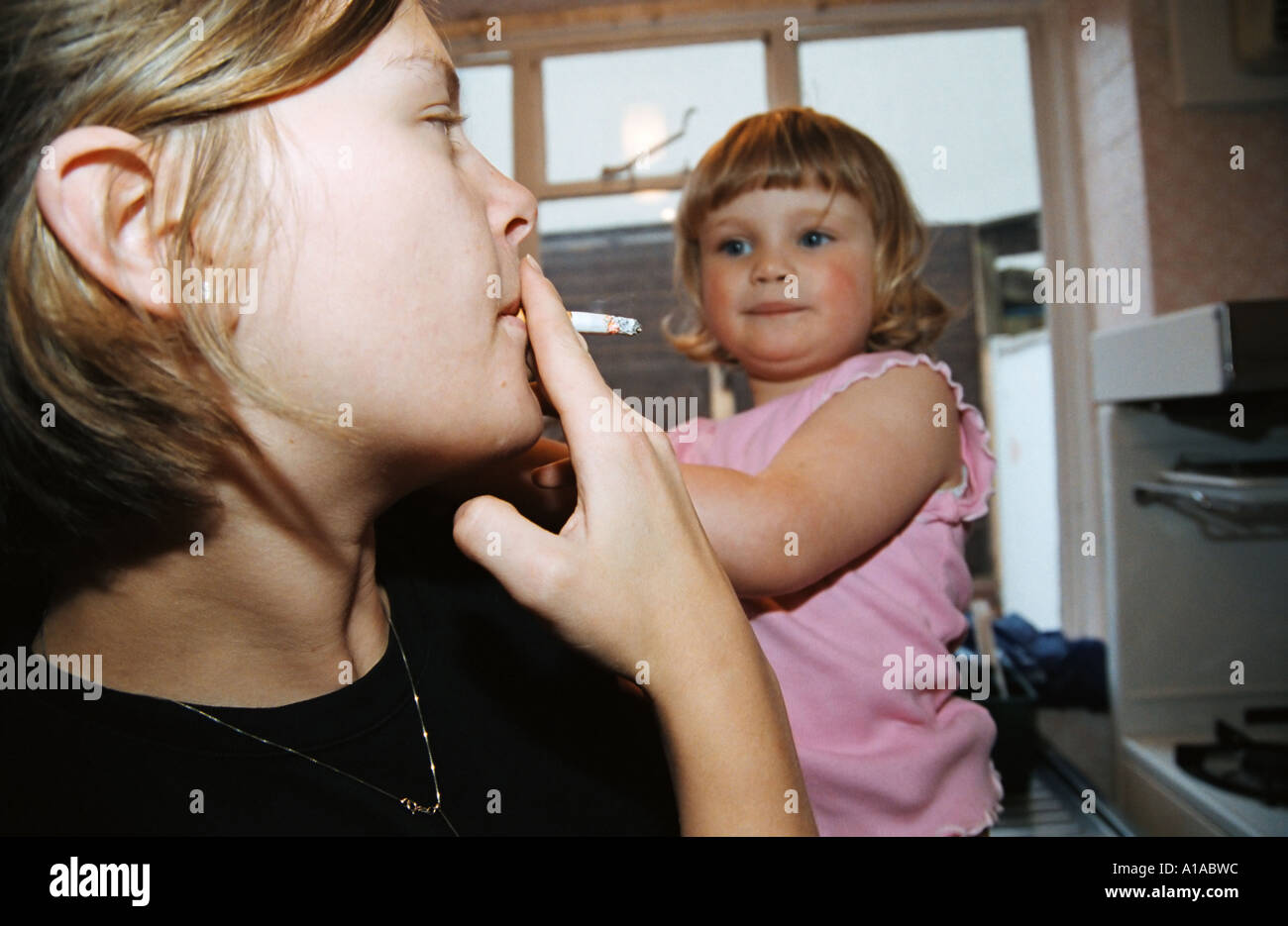 Woman smoking near baby Stock Photo