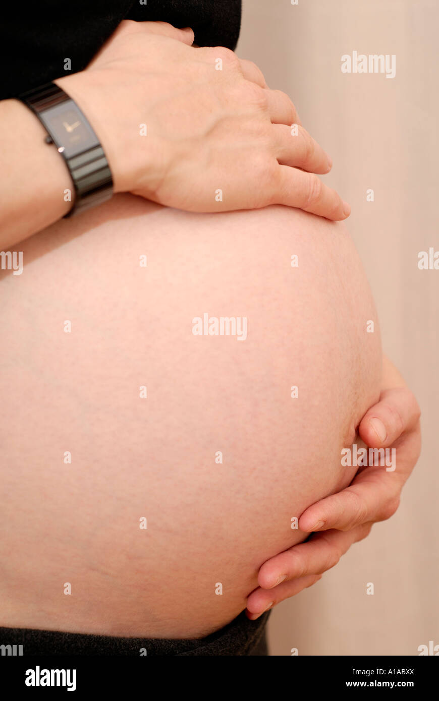 Pregnant woman holding her belly Stock Photo - Alamy