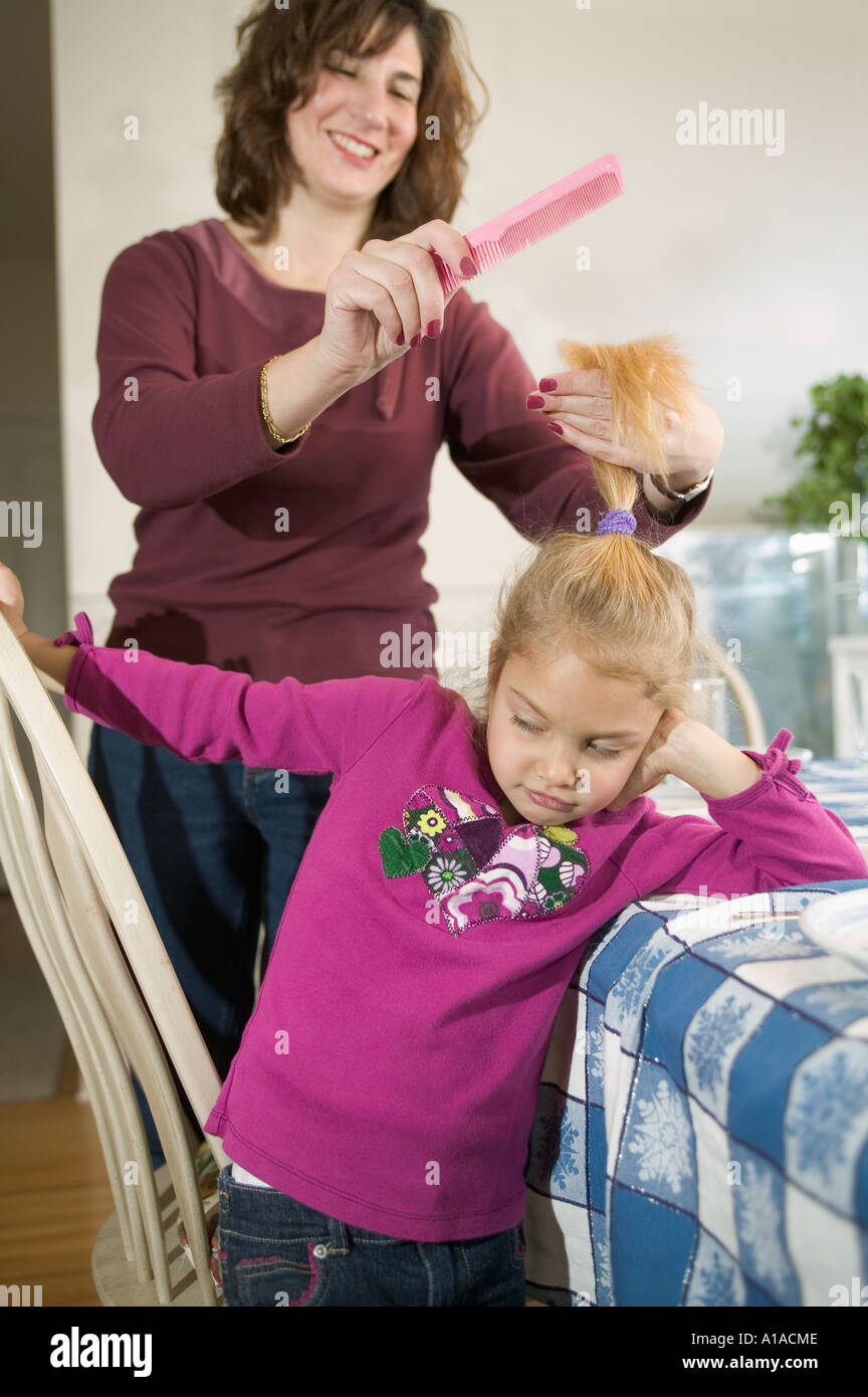 Mother combing daughter's hair Stock Photo