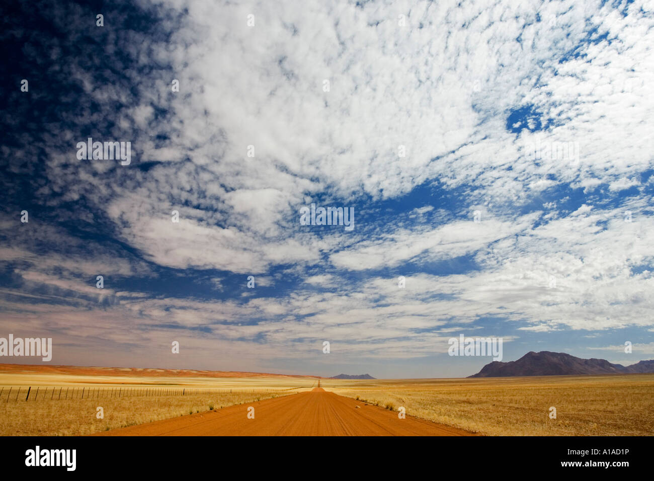 Red gravelroad on the road 707, On the left side the Namib Desert, on the right side the Tiras Mountains, Namibia Stock Photo