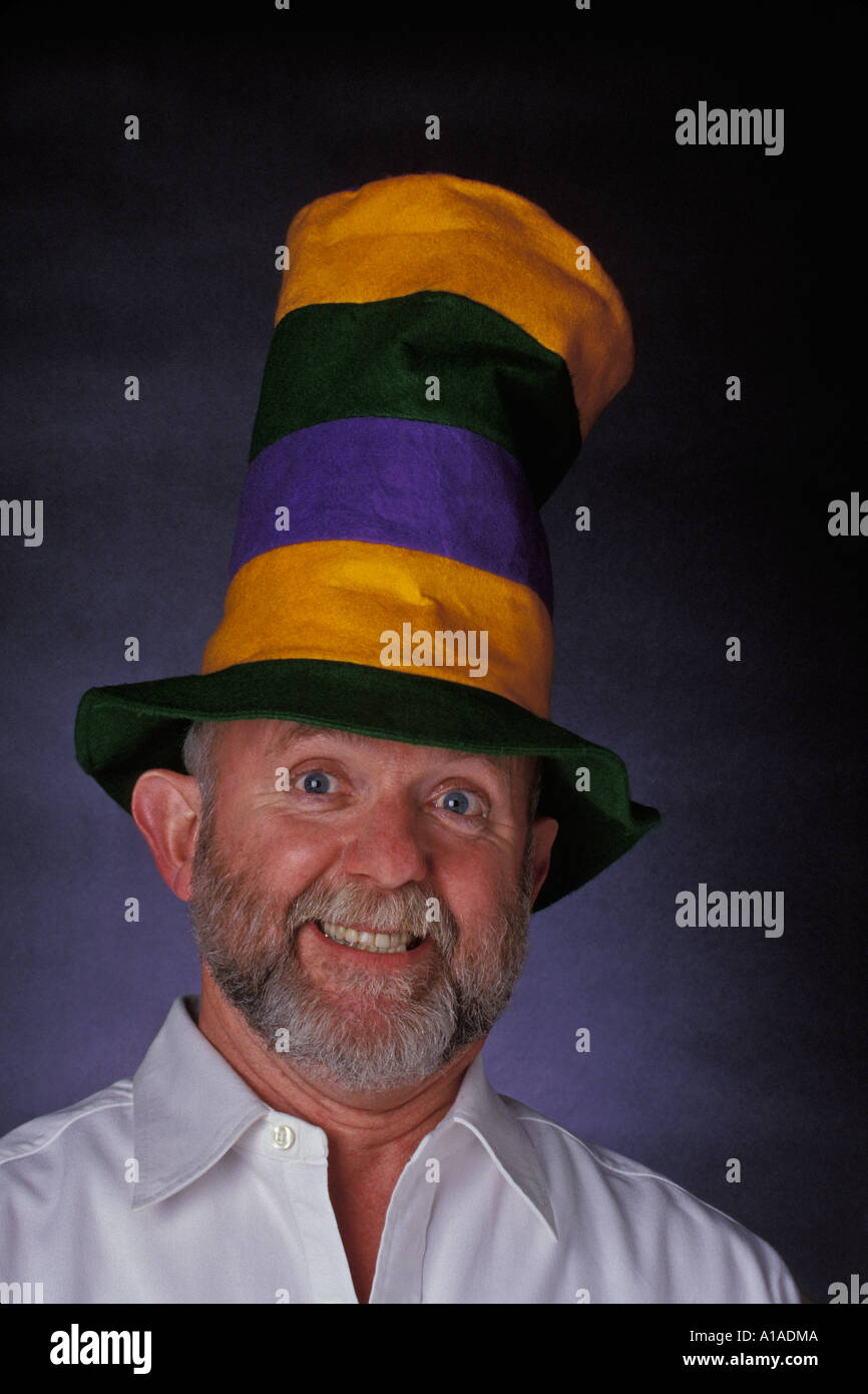 Man with grey beard wearing Dr Seuss Cat in the Hat multi colored tall felt hat and having a good time Stock Photo
