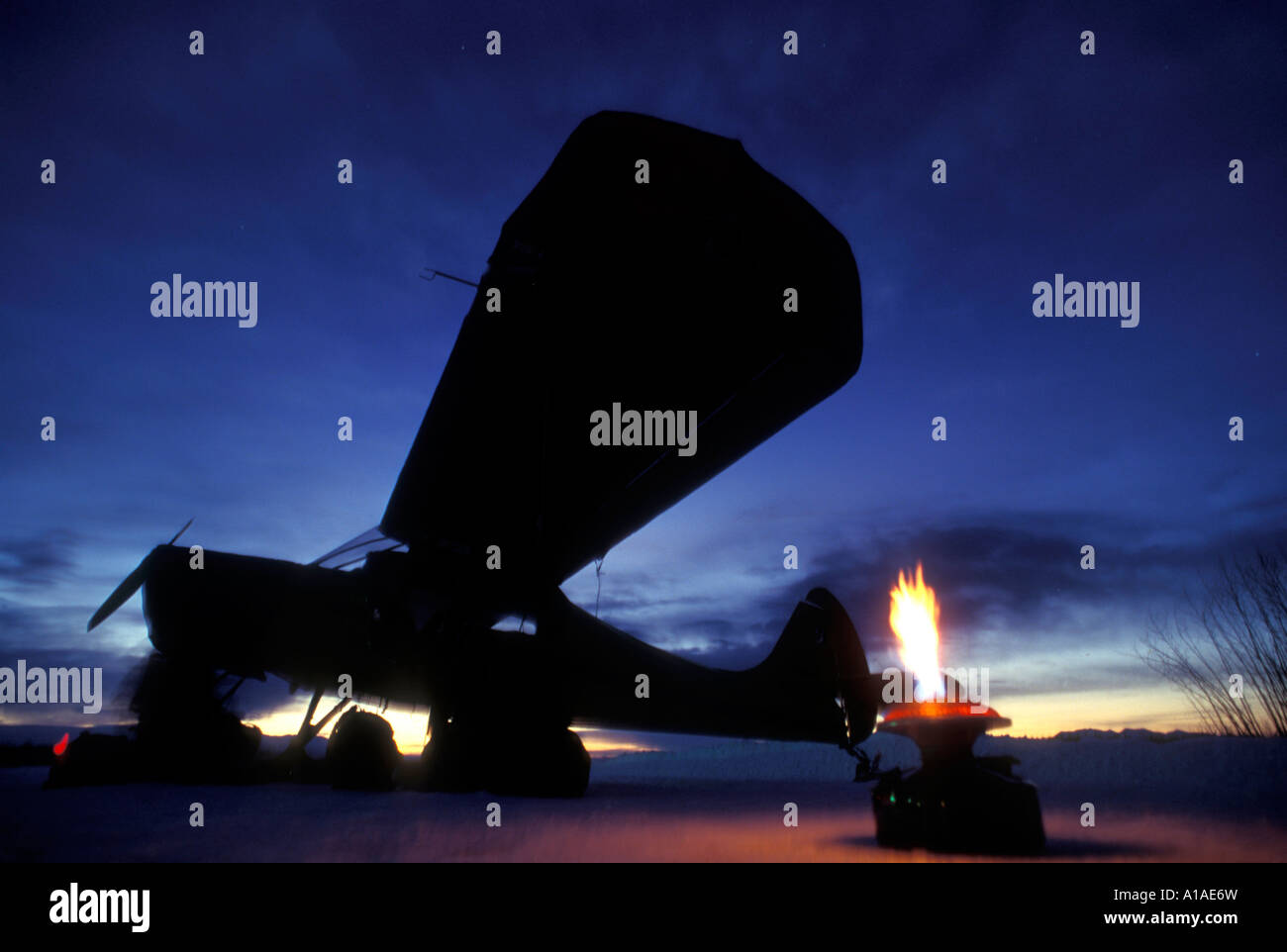 USA Alaska Iditarod pilots gas heater flares in winter dusk at McGrath