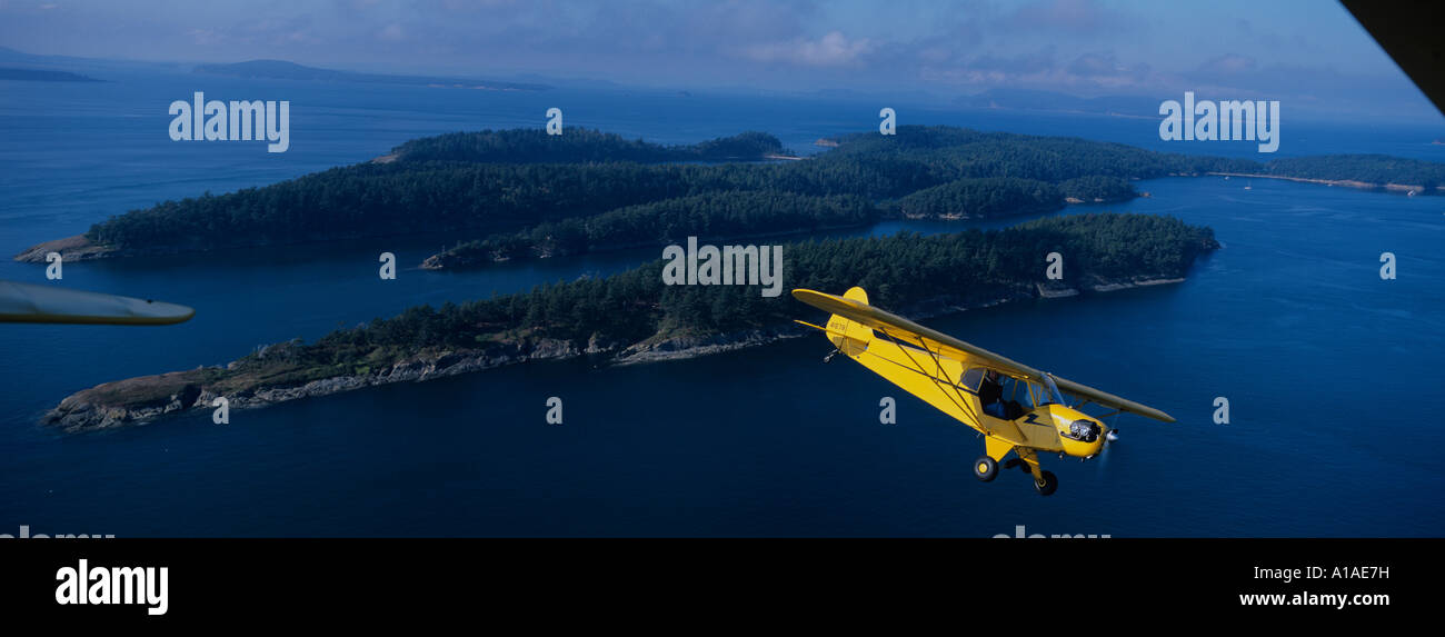 USA Washington Author Richard Bach pilots Piper Cub airplane over Orcas Island in Puget Sound in early morning Stock Photo