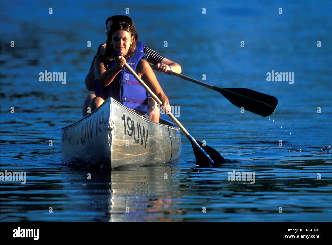 USA Washington Seattle Young women paddle aluminum rental canoe on Lake
