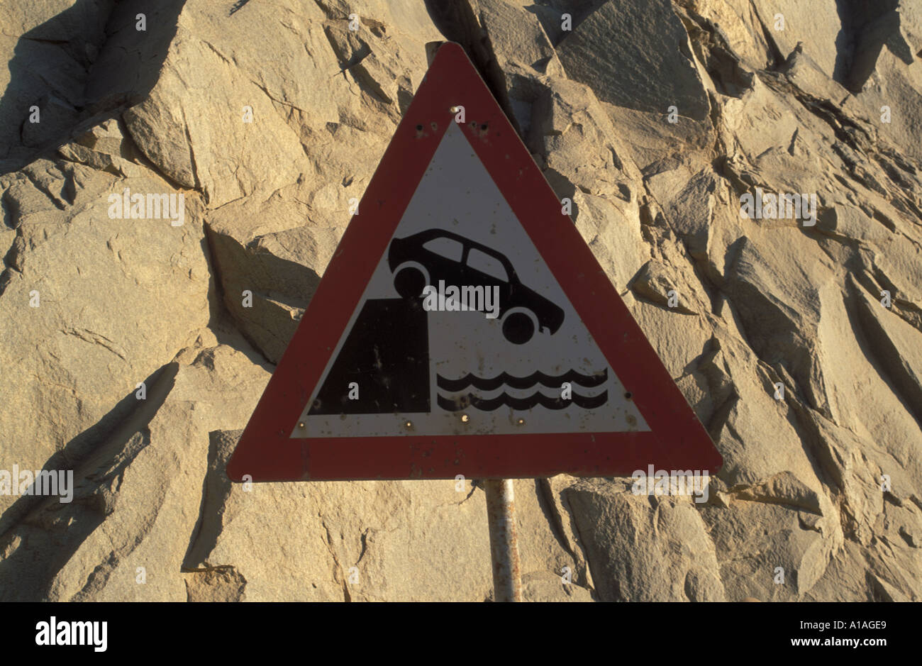 Traffic warning sign for cars warning from driving opver wall to plunge into water Lüderitz Namibia Stock Photo