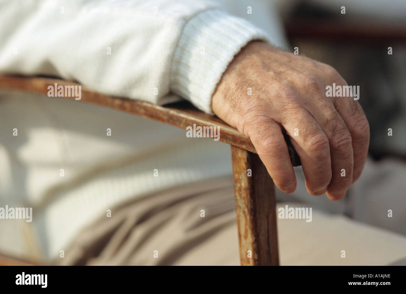 Mans hand resting on chair Stock Photo - Alamy