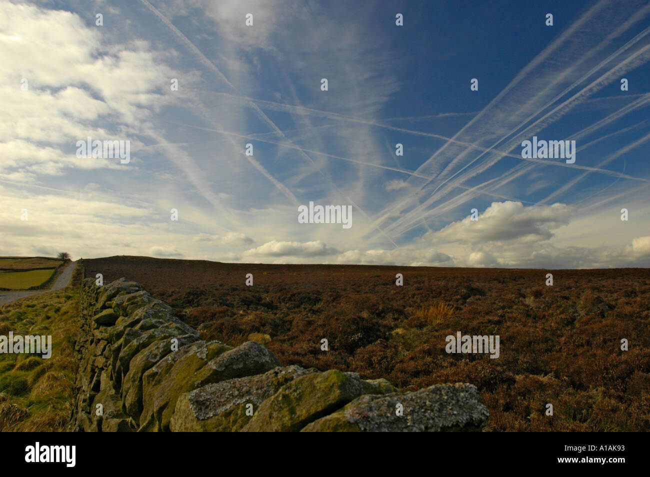 Jet aircraft vapour trails above the Derbyshire countryside UK Stock Photo
