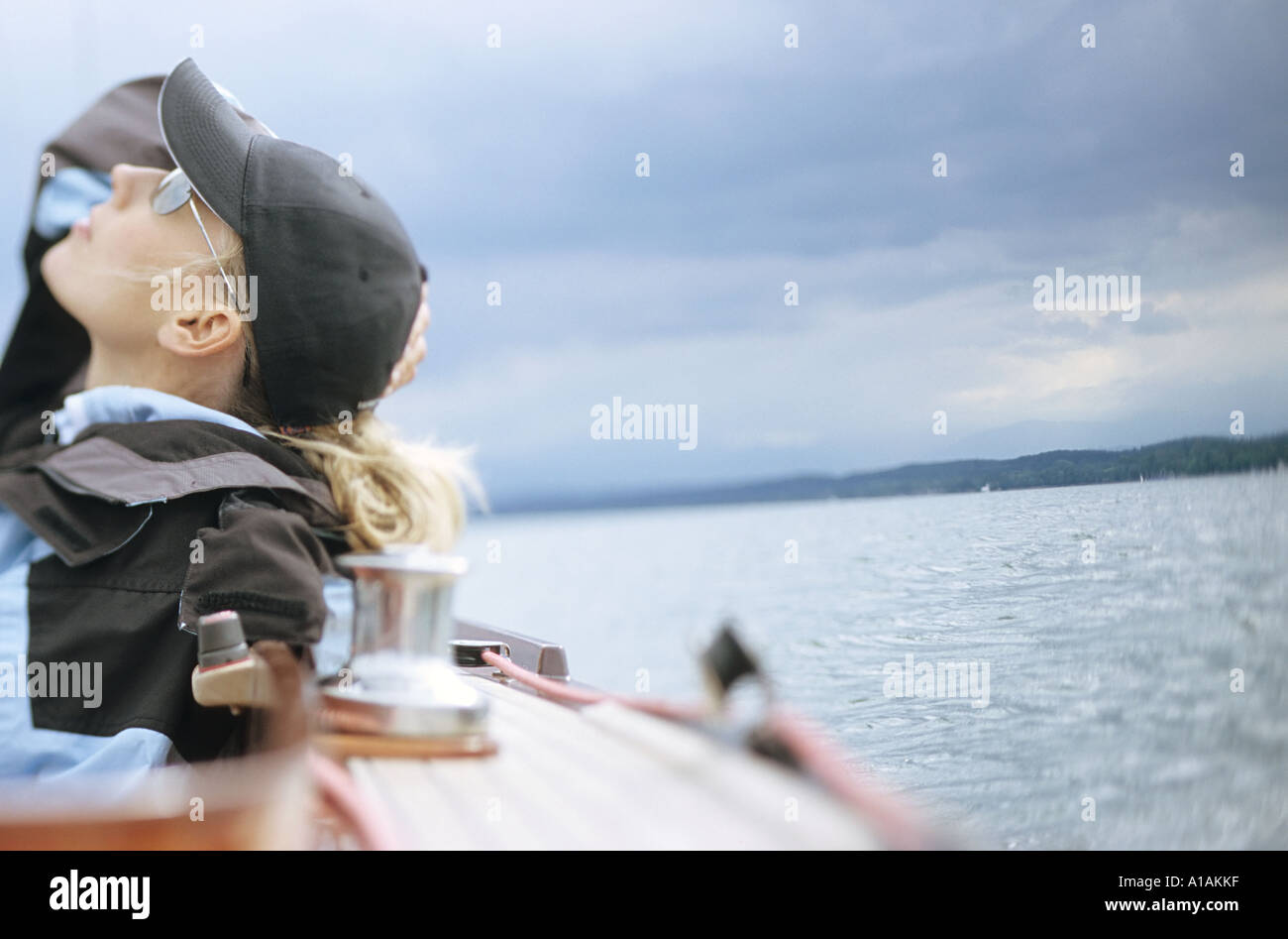 Woman on boat looking up at cloudy sky Stock Photo