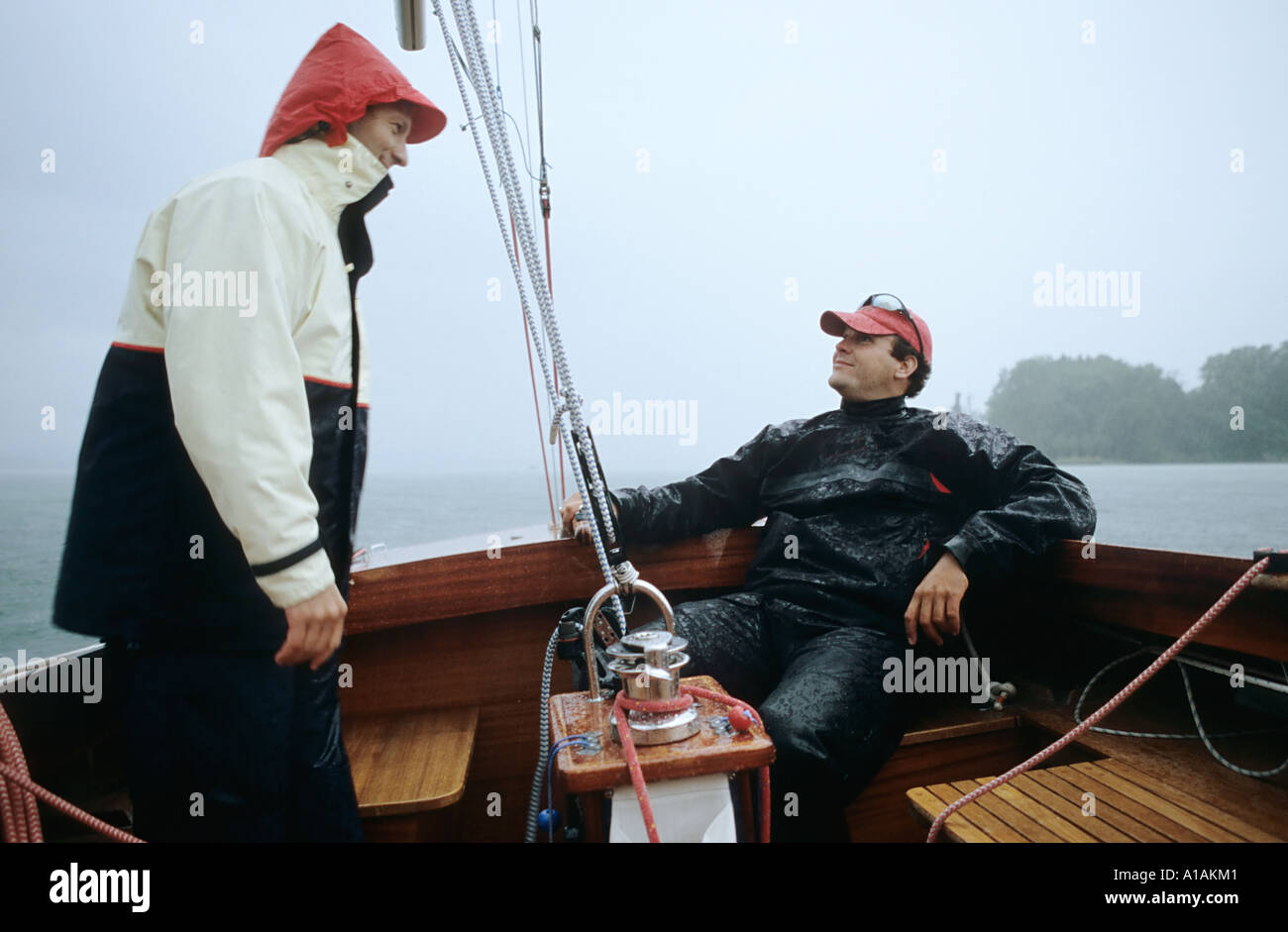 Two men on a boat in the rain Stock Photo