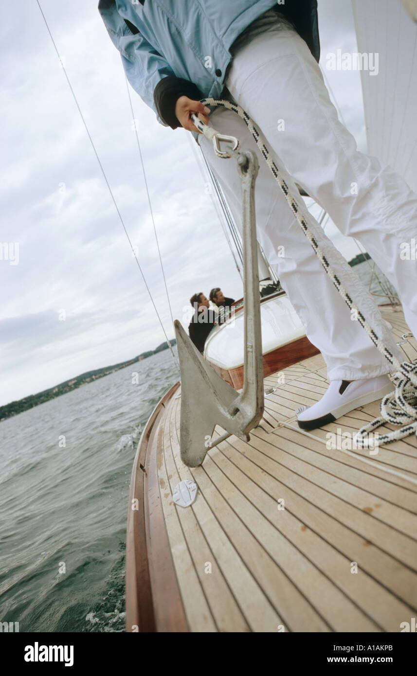 Person on deck of boat holding anchor Stock Photo