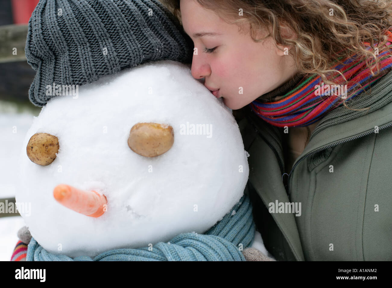 Woman kissing a snowman Stock Photo