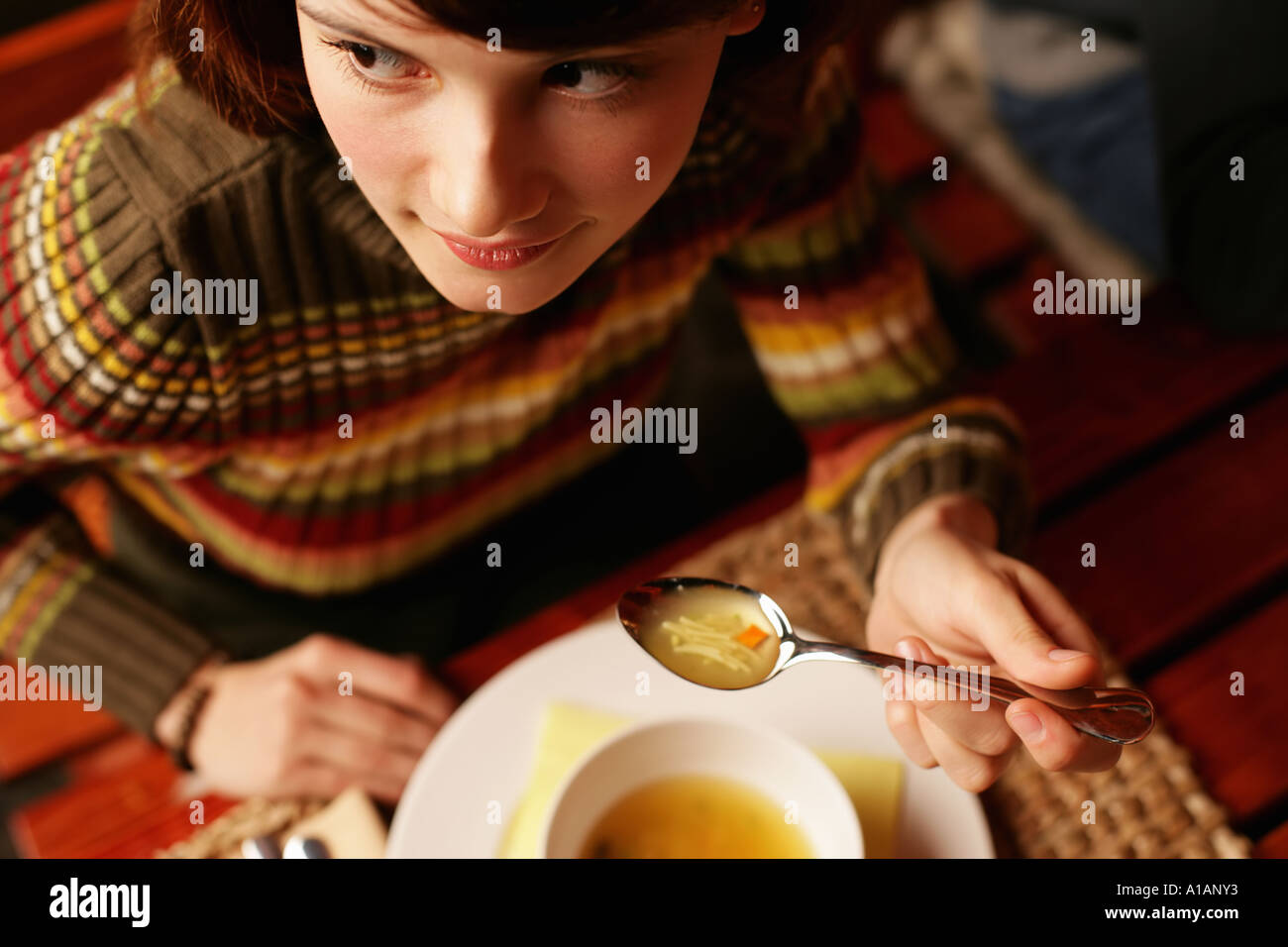 Young woman eating soup Stock Photo