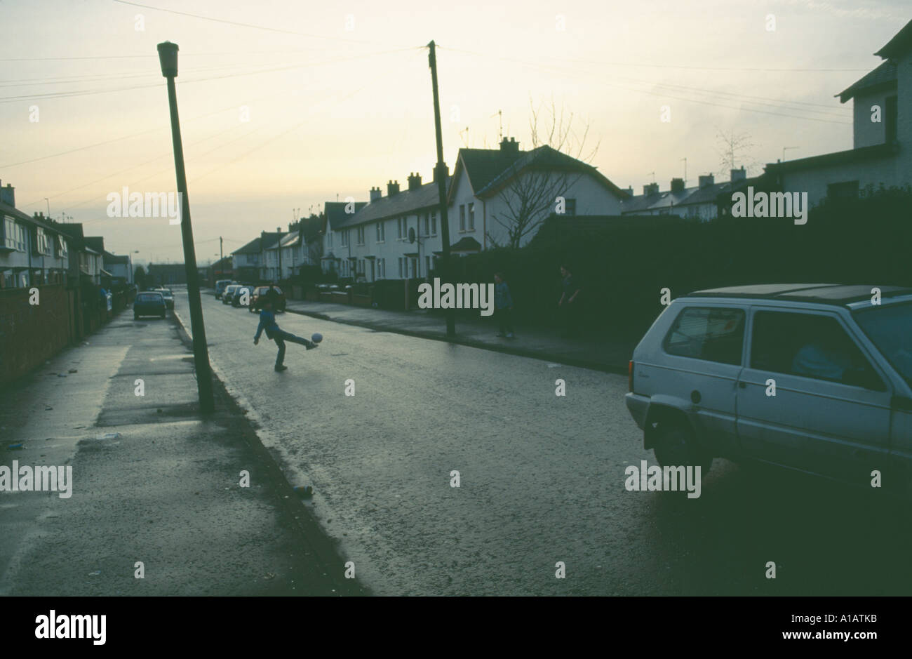 Ireland, North, Belfast, Kids playing soccer in residential street. Stock Photo
