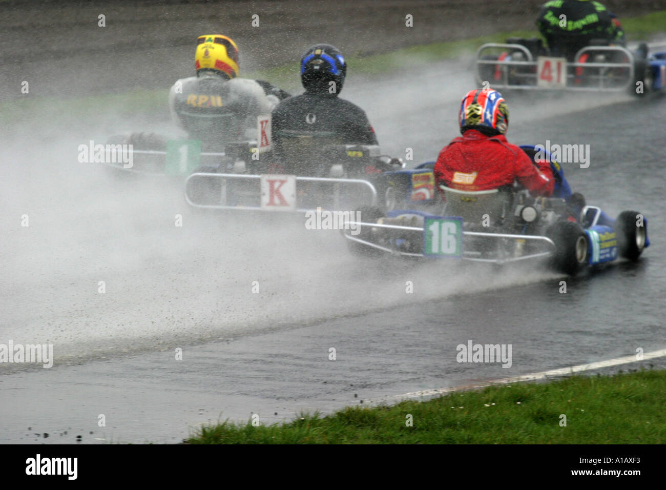 World Formula kart drivers go through a water splash at a wet Nutts