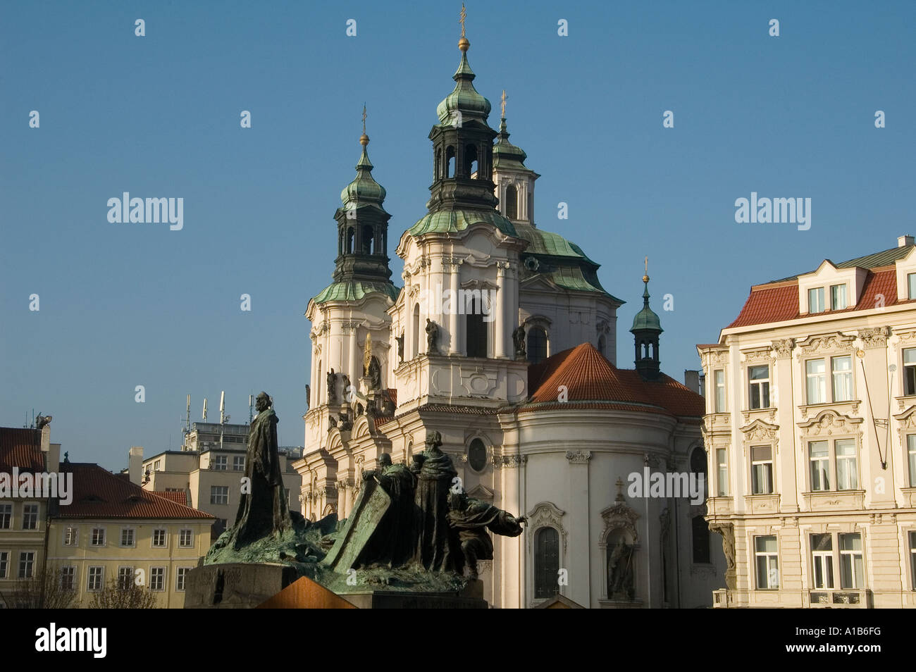 St. Nicholas Church and the Jan Hus monument designed by Ladislav Šalounin unveiled in 1915 at the Old Town Square in Prague, Czech Republic Stock Photo