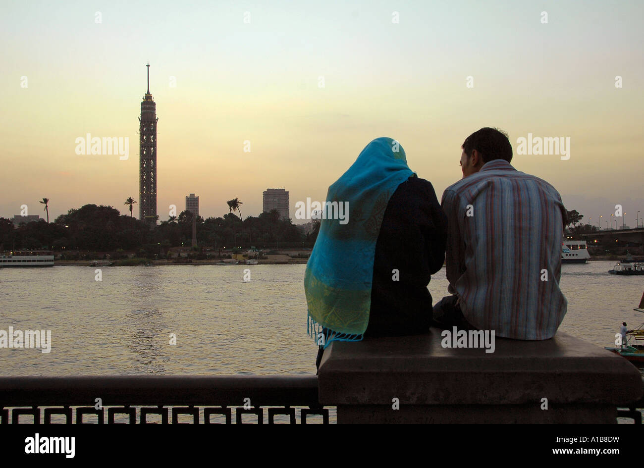 An Egyptian couple siting at the promenade along Nile river in front of