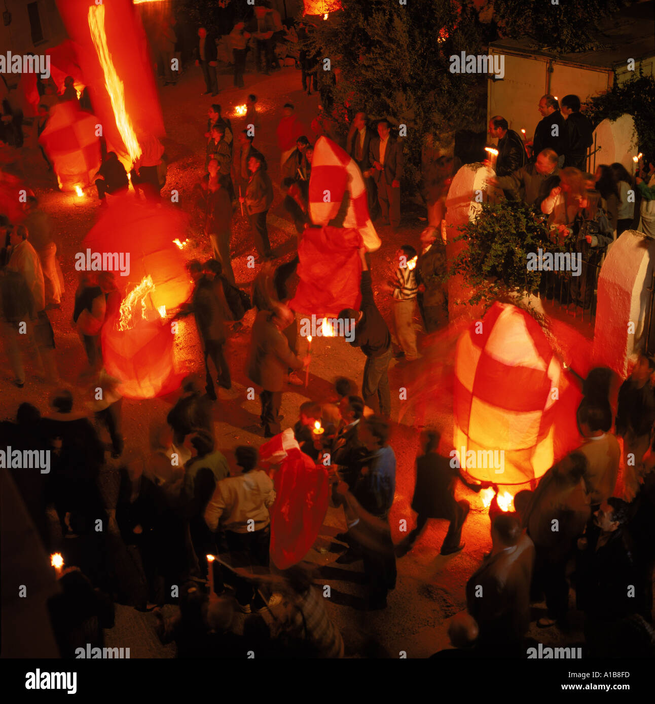 People carrying candles and lighting balloons at night during Easter