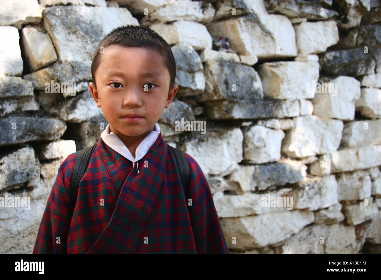 A young Bhutanese boy dressed in a gho the traditional dress for