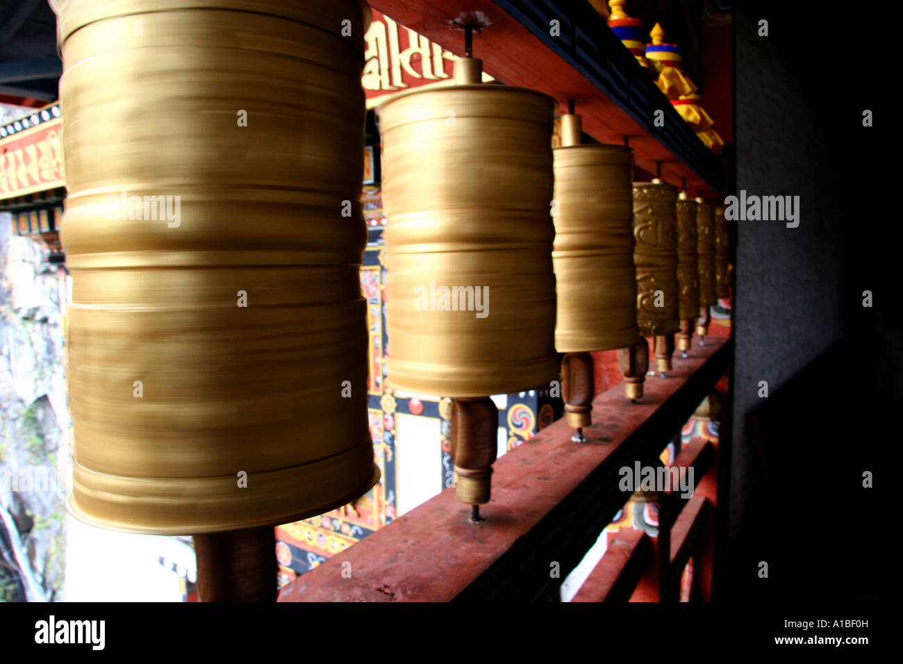 Gold prayer wheels spin on the outside of Taktshang Monastery or Tiger