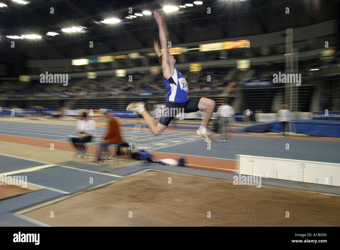 Long jump competitor in mid air at the Irish indoor athletics meeting at the Odyssey Arena Belfast Northern Ireland Stock Photo