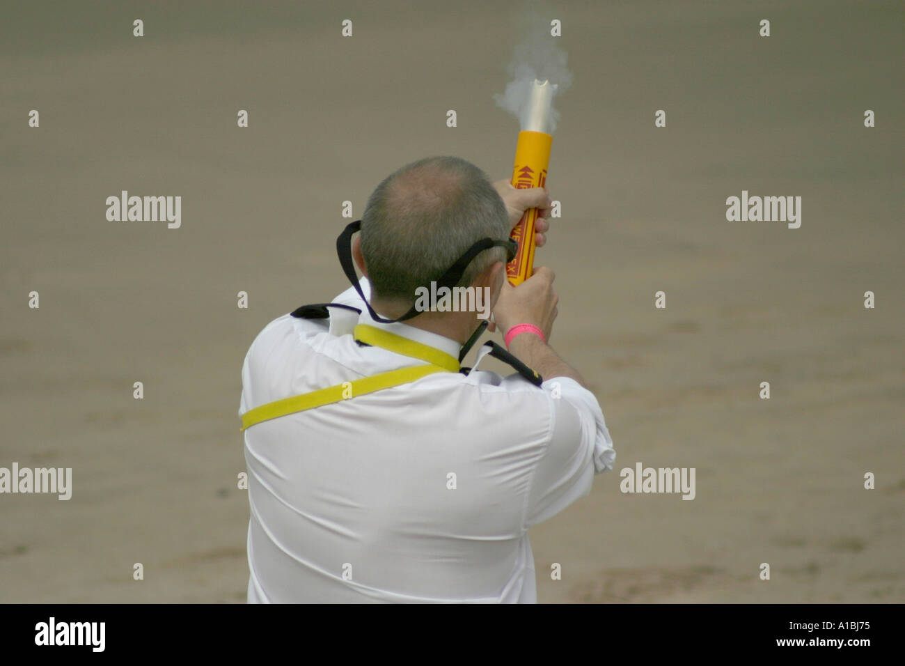 Coastguard officer fires signal flare on Portrush beach to signal start of rescue exercise at Portrush Air Display County Antrim Stock Photo