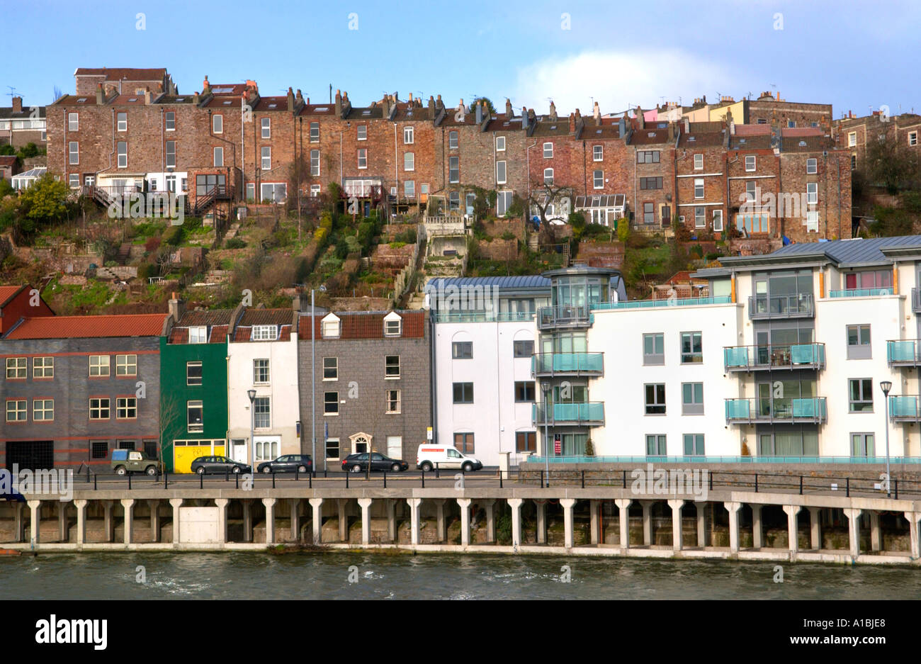 Modern apartment building on Bristol dockside with traditional terraced
