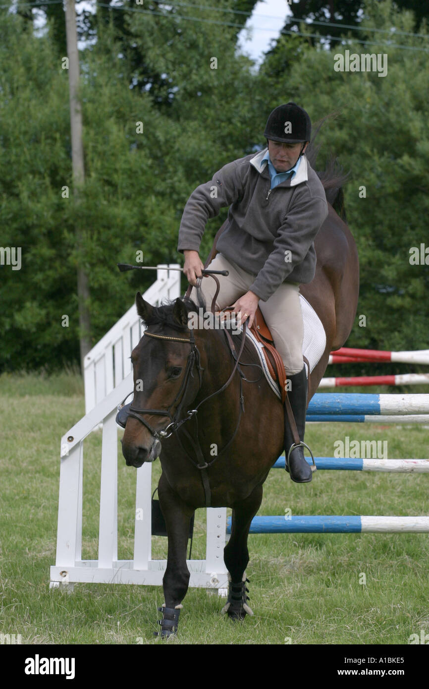 male rider becoming unseated going over a fence at a Gymkana at ...