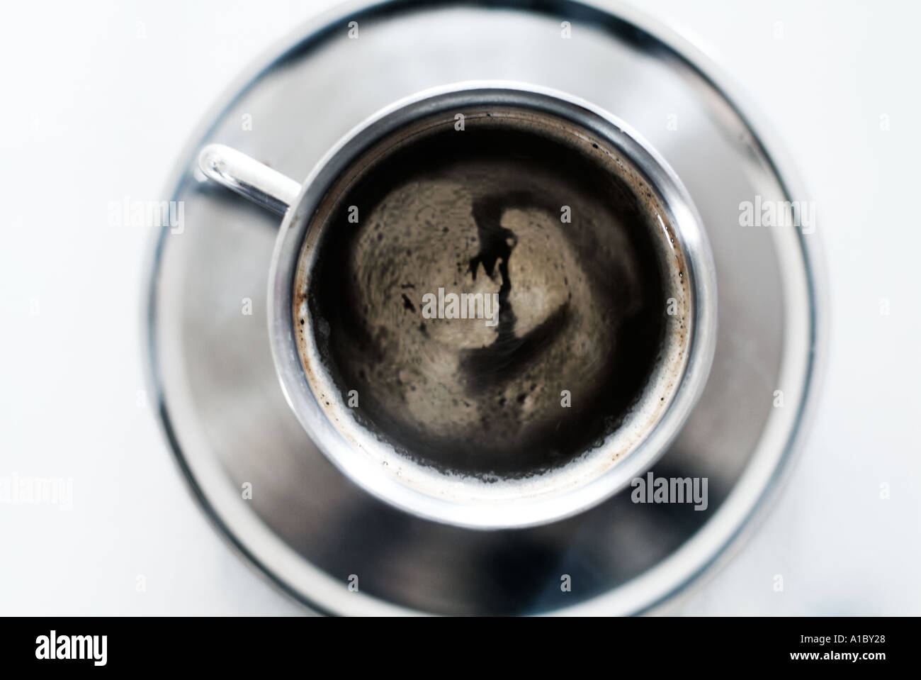 stainless steel cup and saucer with male and female couple kissing depicted in the froth Stock Photo