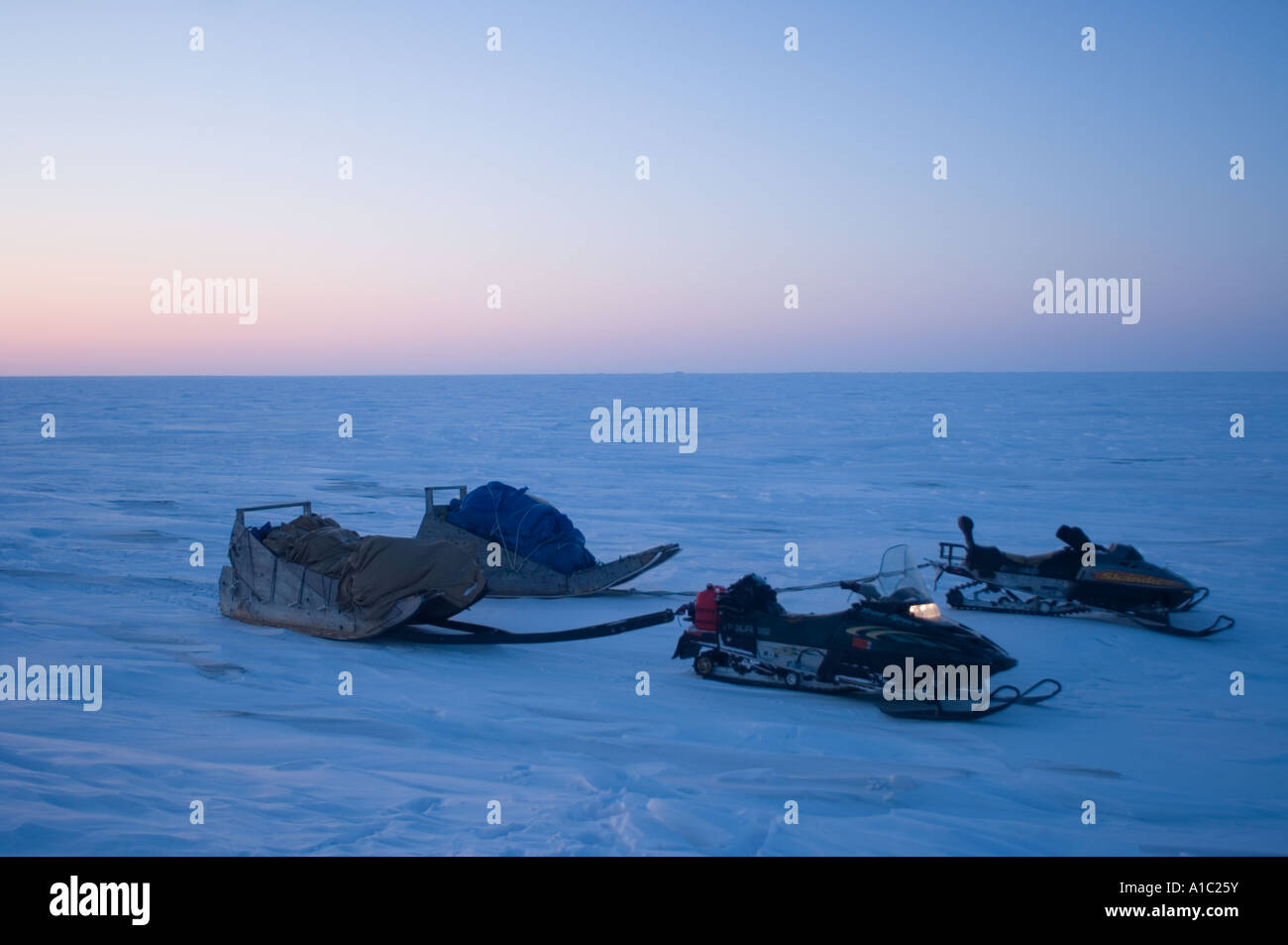 snow machines and sleds with gear on the frozen Arctic ocean travelling