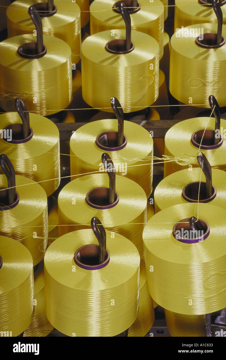 Spools of gold colored Kevlar yarn in the Kevlar III Plant at DuPont's Spruance Advanced Fibers Plant in Richmond Virginia Stock Photo