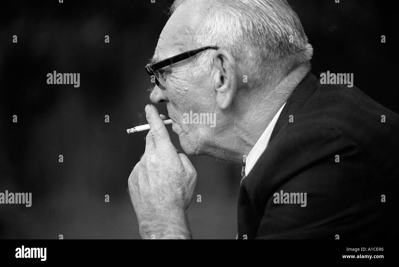 Old man smoking a cigarette. Stock Photo