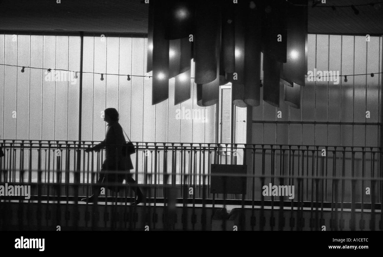 Silhouette of woman walking along a bridge in a shopping center Stock ...