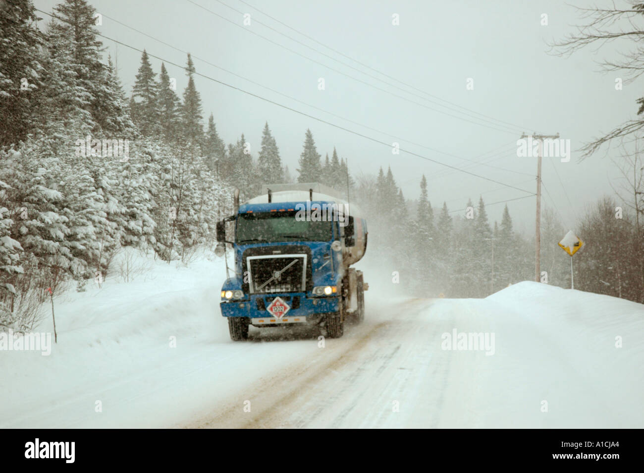Fuel truck making delivery during a snow storm in rural Quebec Canada Stock Photo