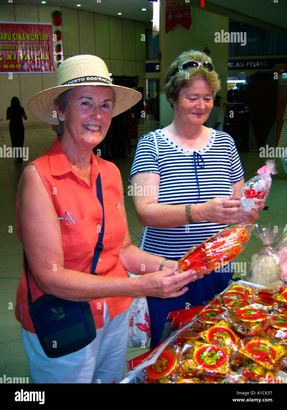 Cruise ship tourist women shop for bargains in the multi level Prangin Mall Komtar Building Georgetown Penang Stock Photo